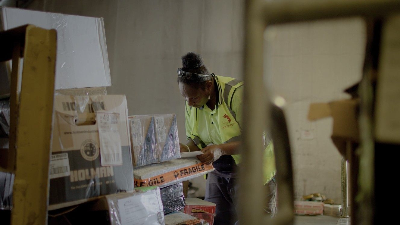Warehouse worker taping a fragile parcel box